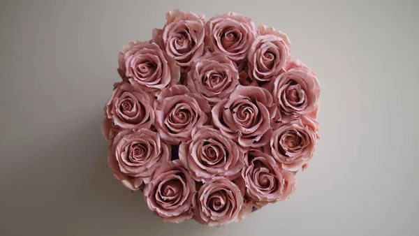 Bouquet of exclusive dusty pink roses on a neutral background.