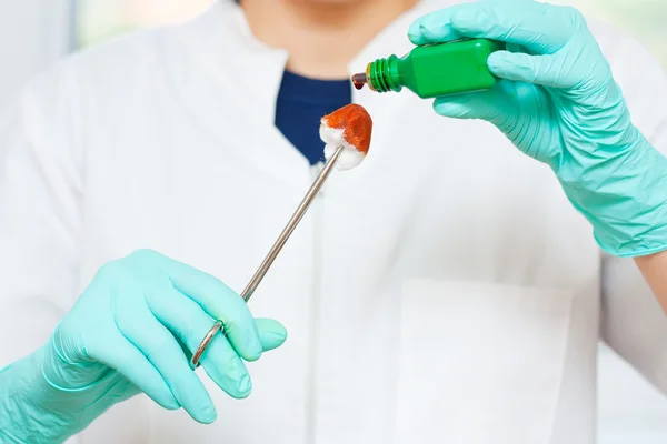 Sağlık görevlisi bazı dezenfektan bir gazlı bez sünger bırakarak