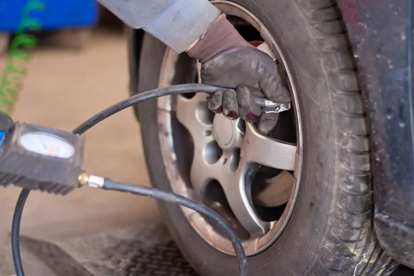 自動車修理店でタイヤの空気圧をチェック ロイヤリティフリーのストック画像
