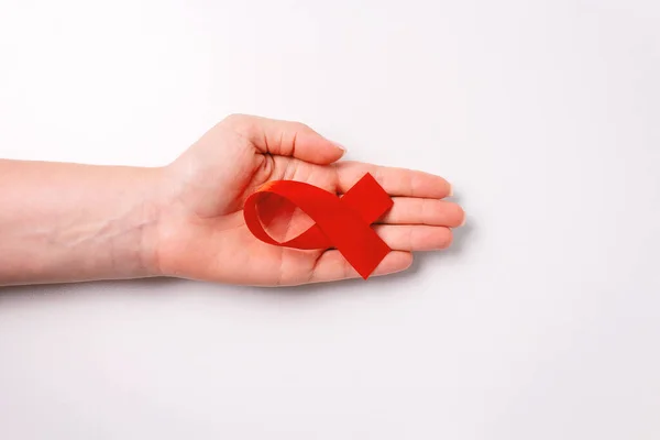 Světový den AIDS. Stuha v ženské ruce. — Stock fotografie