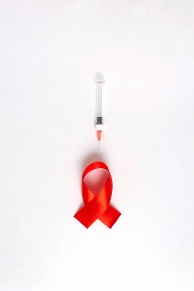 Světový den AIDS. Červená stuha, lékařská stříkačka. — Stock fotografie