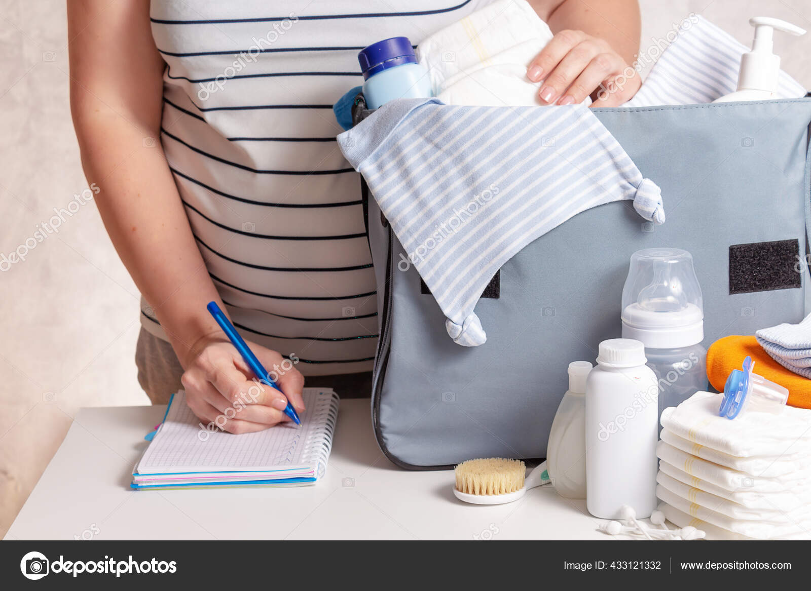 Woman packing diaper bag in maternity hospital. Stock Photo by