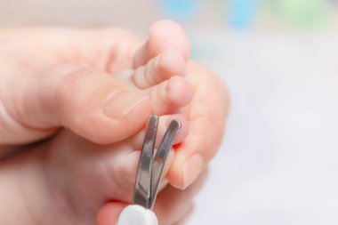 Küçük bebek manikürü. Anne çocukların tırnaklarını kesiyor.. 