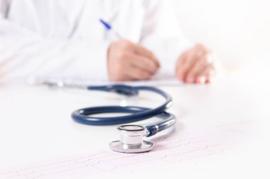 Steteskop yakın çekim. Beyaz üniformalı bulanık doktor..