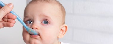 Anne bebeği mavi bebek kaşığıyla besliyor.. 