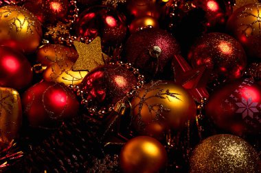 Altın ve kırmızı noel balolarıyla harika bir Noel kompozisyonu. Noel ya da yeni yıl konsepti. Mücevherleri, yıldızları, kalpleri olan karanlık şenlikli bir arka plan.. 