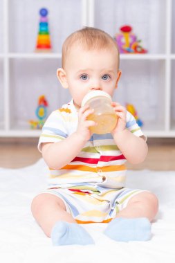 Beyaz, tatlı bir oğlan. Şişeden içiyor..