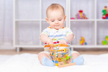 Beyaz erkek bebek ahşap labirentle oynuyor..