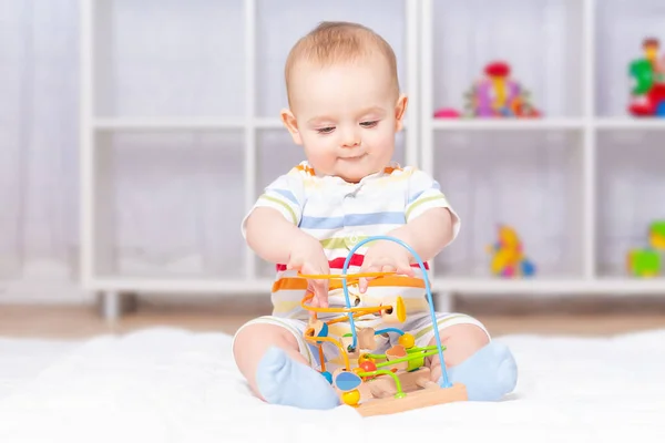 Caucasiano menino brincando com labirinto de madeira. — Fotografia de Stock