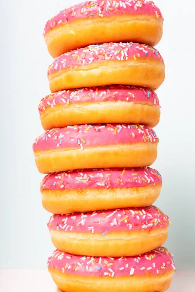 ピンクの釉ドーナツのスタック。接近中だ。垂直. — ストック写真