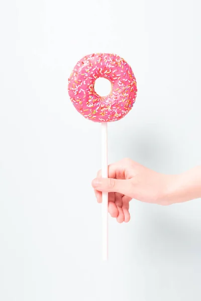 Pink donut in childs hand like lollipop. — Stock Photo, Image
