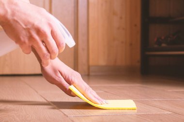 Kadın seramik zemini spreyle temizliyor.. 