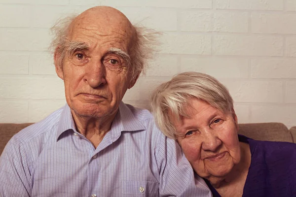 Abuela y abuelo abrazándose juntos en el sofá. — Foto de Stock