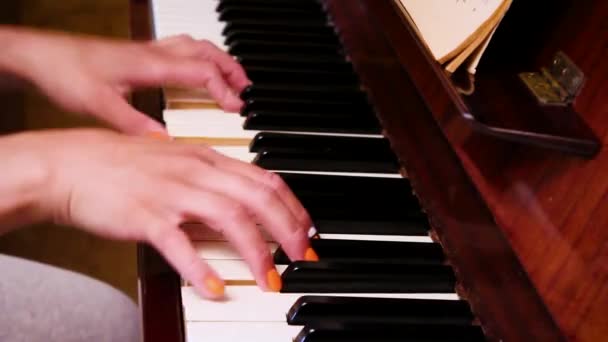 Blank meisje speelt piano met twee handen. Sluiten.. — Stockvideo