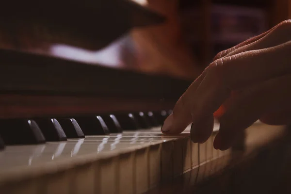 Woman playing piano. Close-up. Fingers on keys.