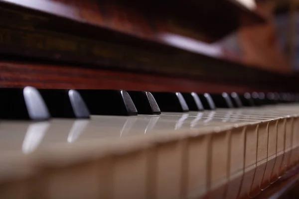 Close up of black and white piano keys. Selective focus. Vintage brown piano.