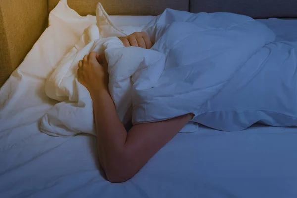 Uykusuzluk konsepti. Kadınlar ellerini beyaz battaniyeye koyar. — Stok fotoğraf