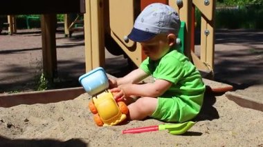 Beyaz, sevimli erkek bebek arabayla oynuyor..