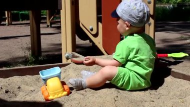 Beyaz, sevimli erkek bebek arabayla oynuyor..