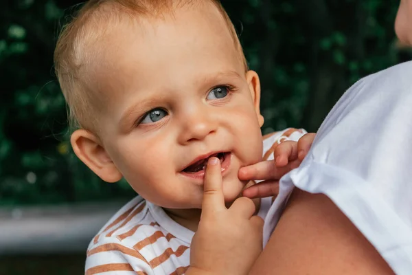 Pequeño niño mira por encima de su hombro madres. Imagen De Stock