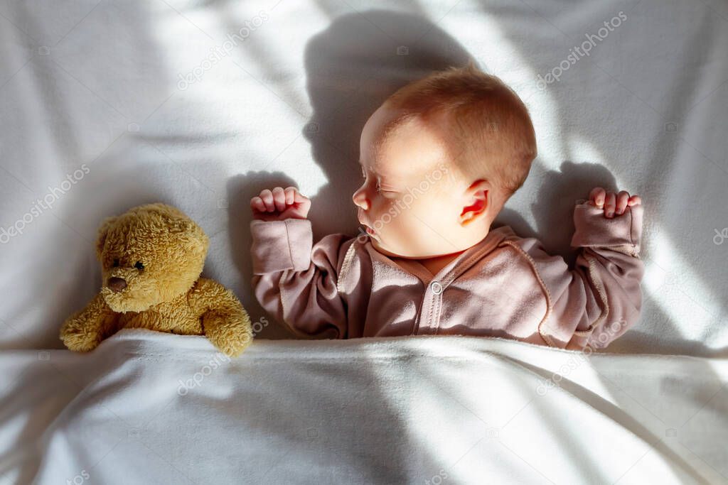 Newborn baby sleeping home with first toy. 