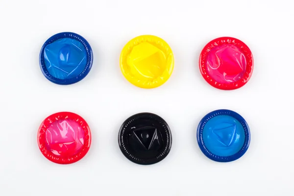 Разноцветные презервативы на белом фоне — стоковое фото