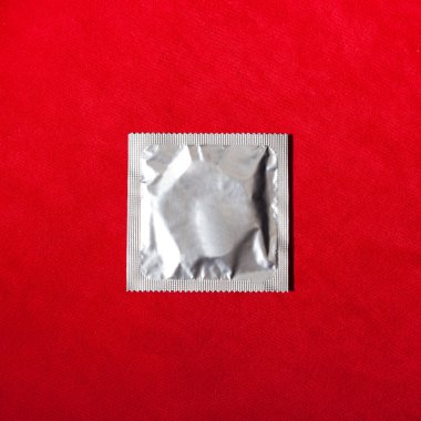 Prezervatif kırmızı Tekstil arka plan üzerinde