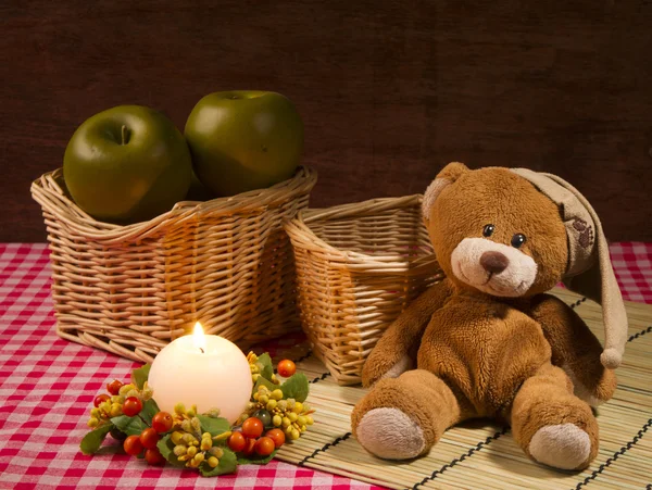 Teddy bear, candle and apples — Stock Photo, Image