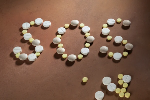 Inscription sos made of tablets — Stock Photo, Image