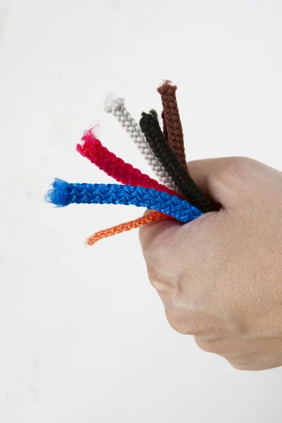 The hand with the colored end of the rope — Stock Photo, Image