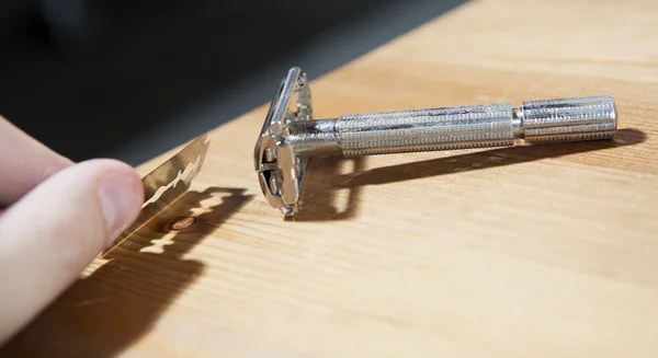 Razor and blade on wooden table — Stock Photo, Image