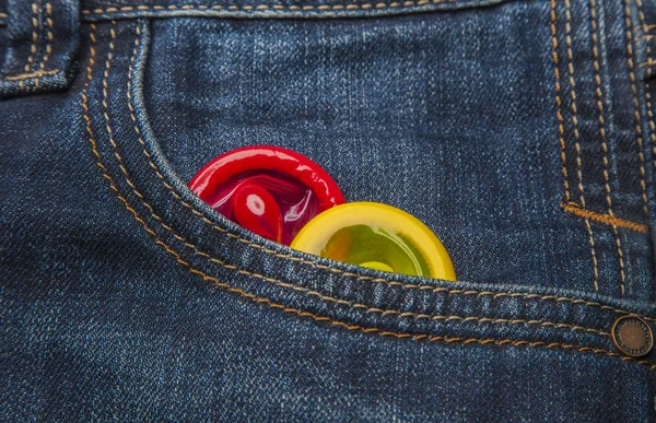 Цветные презервативы в кармане джинсов — стоковое фото