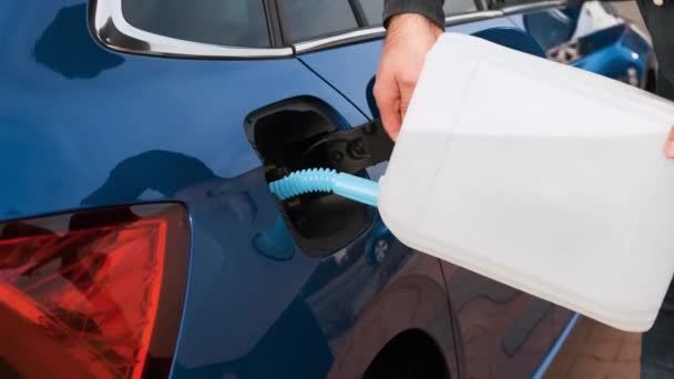 Cierre el hombre llenando un motor diesel o líquido de escape DEF del recipiente en el tanque de coche azul. — Vídeos de Stock