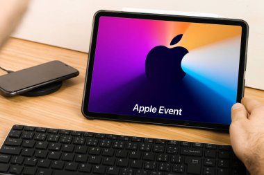 Tablet ekranında Apple Event Logosu var. Apple Park 'tan sunum izleyen adam. İllüstrasyon makalesi. San Francisco, Kasım 2020.