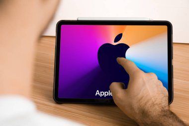 Tablet ekranında Apple Event Logosu var. Apple Park 'tan sunum izleyen adam. İllüstrasyon makalesi. San Francisco, Kasım 2020.