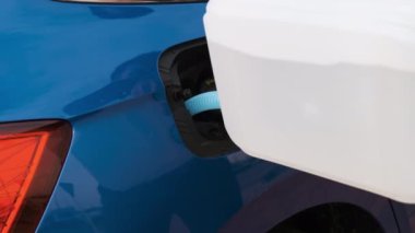 Diesel motor sıvısını mavi bir arabanın deposuna dolduran adamı kapatın..