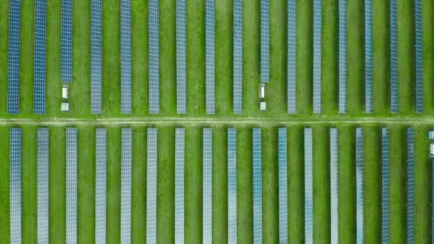 飞越一个太阳能发电厂生产电力.绿地中太阳能电池板的垂直直线.无害生态的可再生能源. — 图库视频影像