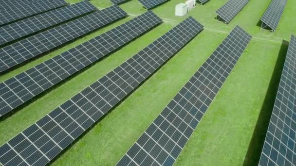 Yeşil alanda güneş paneli boyunca uçmak. Yeşil enerji üretimi için güneş enerjisi santrali. Güneş panelinde gökyüzünün yansıması — Stok video