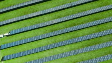 Yeşil alandaki güneş panelleri üzerinde dönen havadan. Fotovoltaik enerji santrali