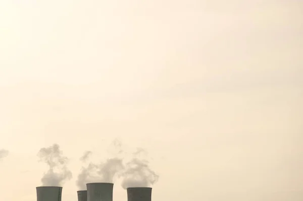 コピースペースのセピアトーンで原子力発電所の4つの煙突の上 電力の生産 工業用煙 — ストック写真
