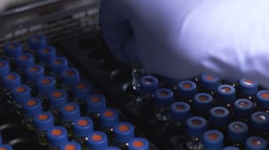 Bilim adamı numuneleri HPLC analizi için otomatik örnekleyiciye koydu. Koronavirüse karşı aşı testi. Tıbbi örneklerle çalışma süreci.