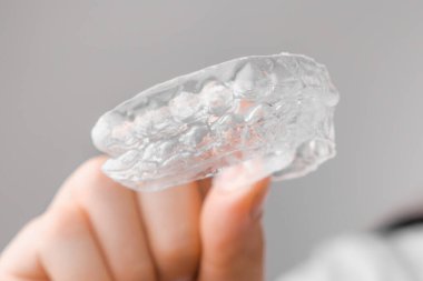 Kadının elindeki temiz dizilimlere yakın durun. Diş beyazlatma ve düzeltme için ortodontik tedavi