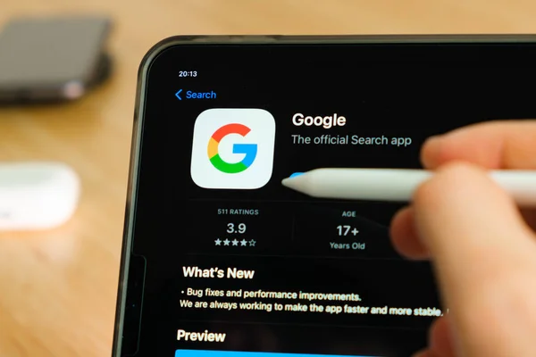 Logo de Google mostrado por el lápiz de manzana en la pantalla de la tableta iPad Pro. Hombre usando la aplicación en la tableta. Diciembre 2020, San Francisco, EE.UU.. — Foto de Stock