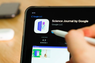 iPad Pro tablet ekranında elmalı kalemle gösterilen Google logosuyla bilim günlüğü. Tabletteki uygulamayı kullanan adam. Aralık 2020, San Francisco, ABD.