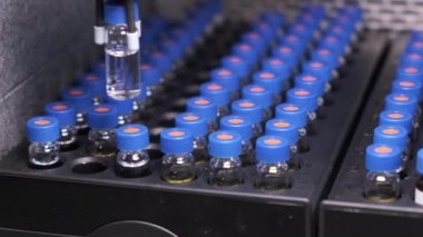 Kromatografik robotik cihazın otomatik taşıma hattı. Tüplerdeki tıbbi örneklerle yapılan çalışmalar. HPLC sistemi kullanılarak aşı denemesi.