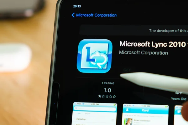 Логотип Microsoft Lync 2010 показан яблочным карандашом на экране планшета iPad Pro. Человек, использующий приложение на планшете. Декабрь 2020, Сан-Франциско, США. — стоковое фото