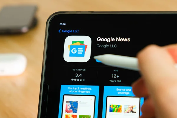 Google News logosu iPad Pro tablet ekranında elma kalemle gösteriliyor. Tabletteki uygulamayı kullanan adam. Aralık 2020, San Francisco, ABD.