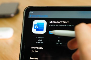 iPad Pro tablet ekranında elmalı kalemle gösterilen Microsoft Word logosu. Tabletteki uygulamayı kullanan adam. Aralık 2020, San Francisco, ABD.
