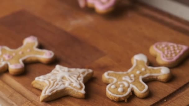 Woman puts a cookie in the shape of heart with royal icing for Valentines Day on the wooden table — Stock Video