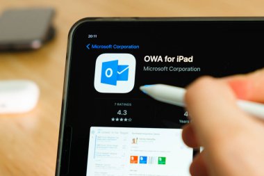 iPad Pro tablet ekranında elmalı kalemle gösterilen Microsoft OWA fo iPad logosu. Tabletteki uygulamayı kullanan adam. Aralık 2020, San Francisco, ABD.